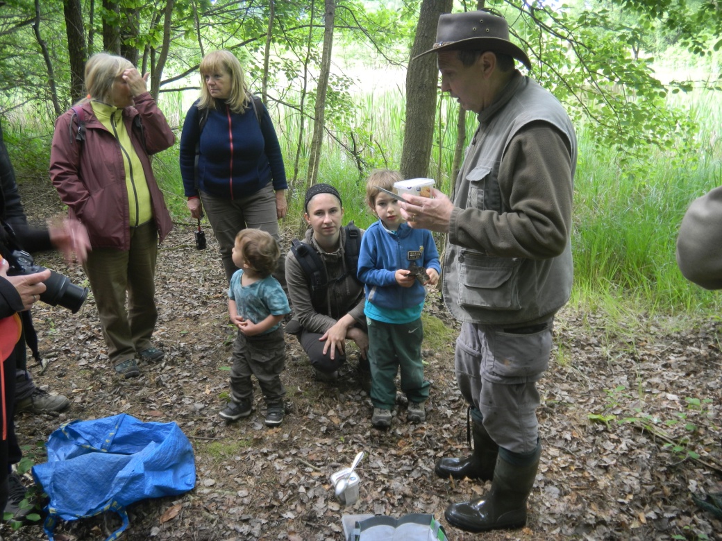 Účastníci vycházky sledují výklad průvodce.